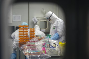 Медицинские работники в защитных костюмах в лаборатории по обнаружению коронавируса